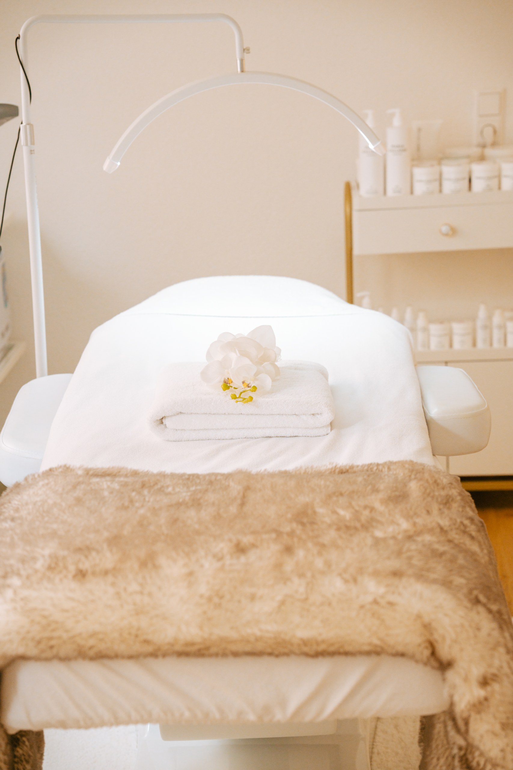 Behandlungsliege mit Felldecke und Orchidee