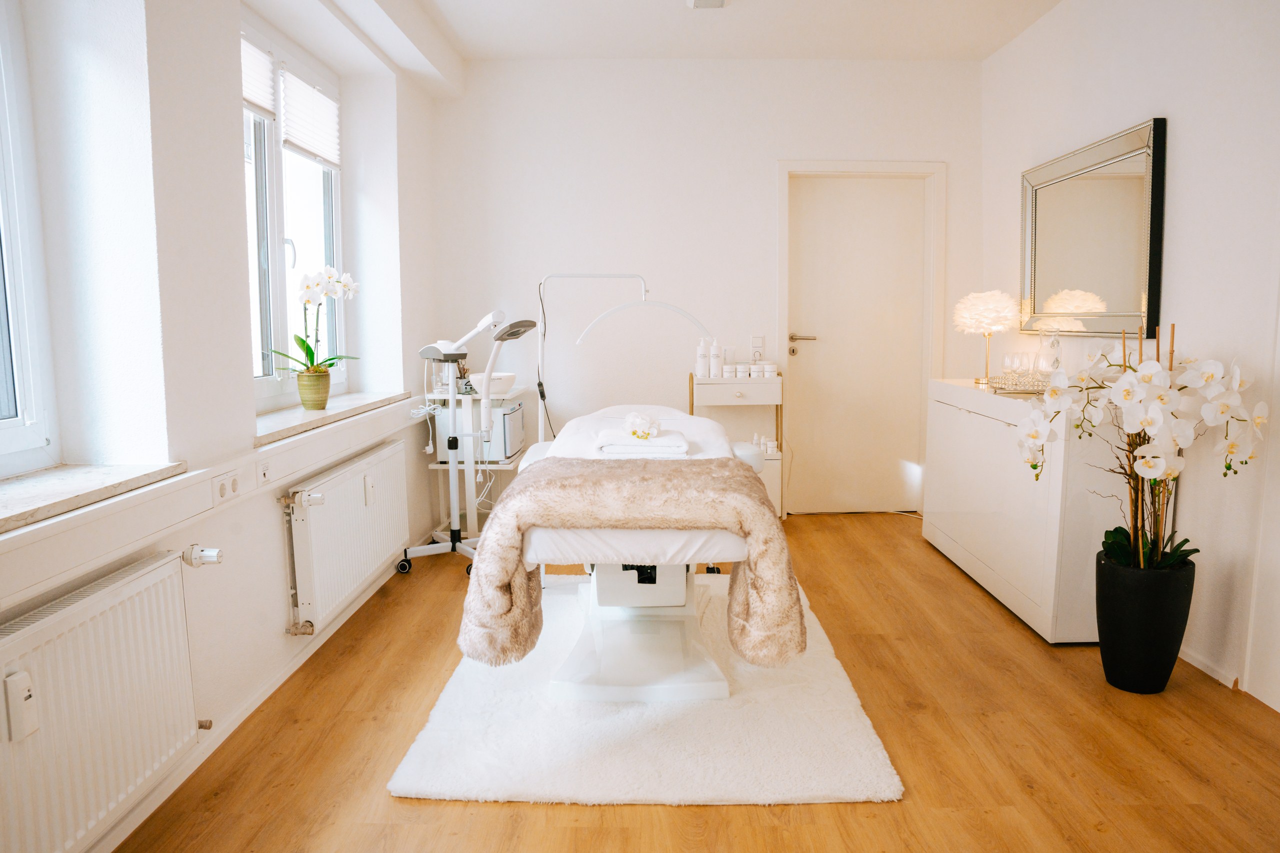 Behandlungsraum des Beauty Studio No5 mit Liege, Orchideen und warmem Licht