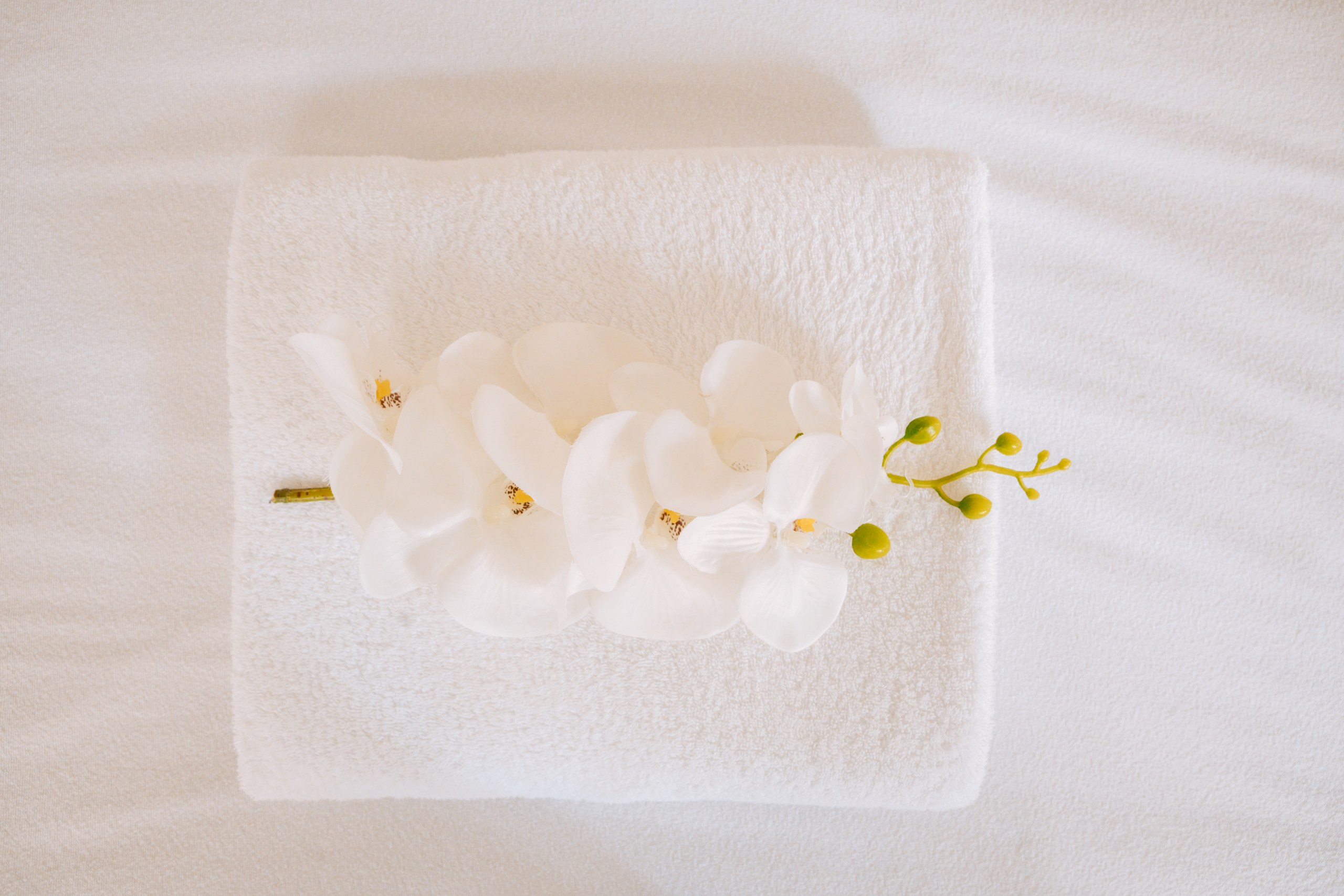 Handtuch mit Orchidee auf der Behandlungsliege